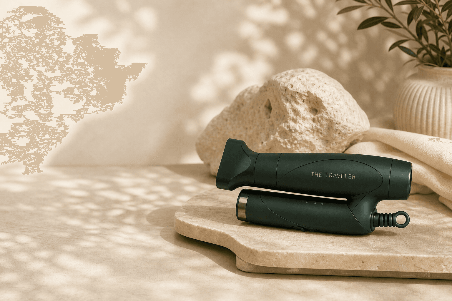 The Traveler folding dryer resting on warm travertine in dappled light